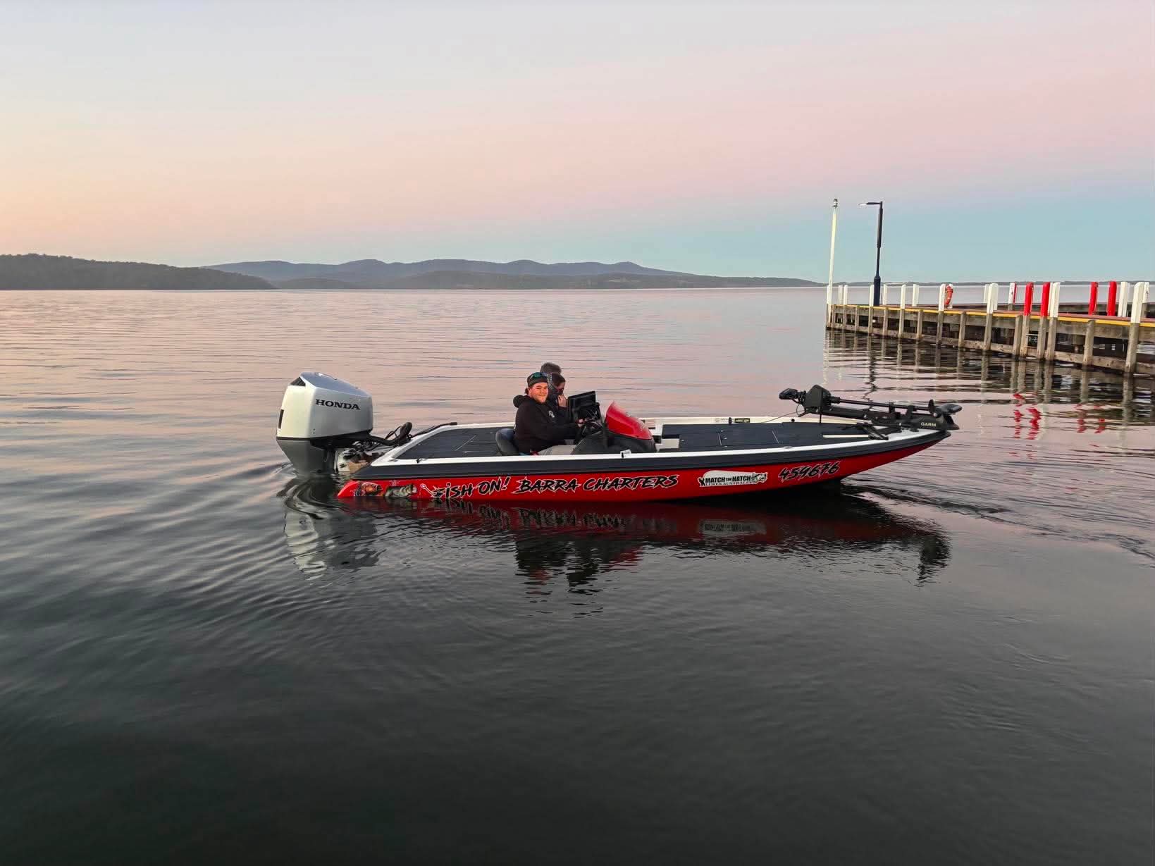 Boat on glassy water at sunrise near the Mallacoota jetty