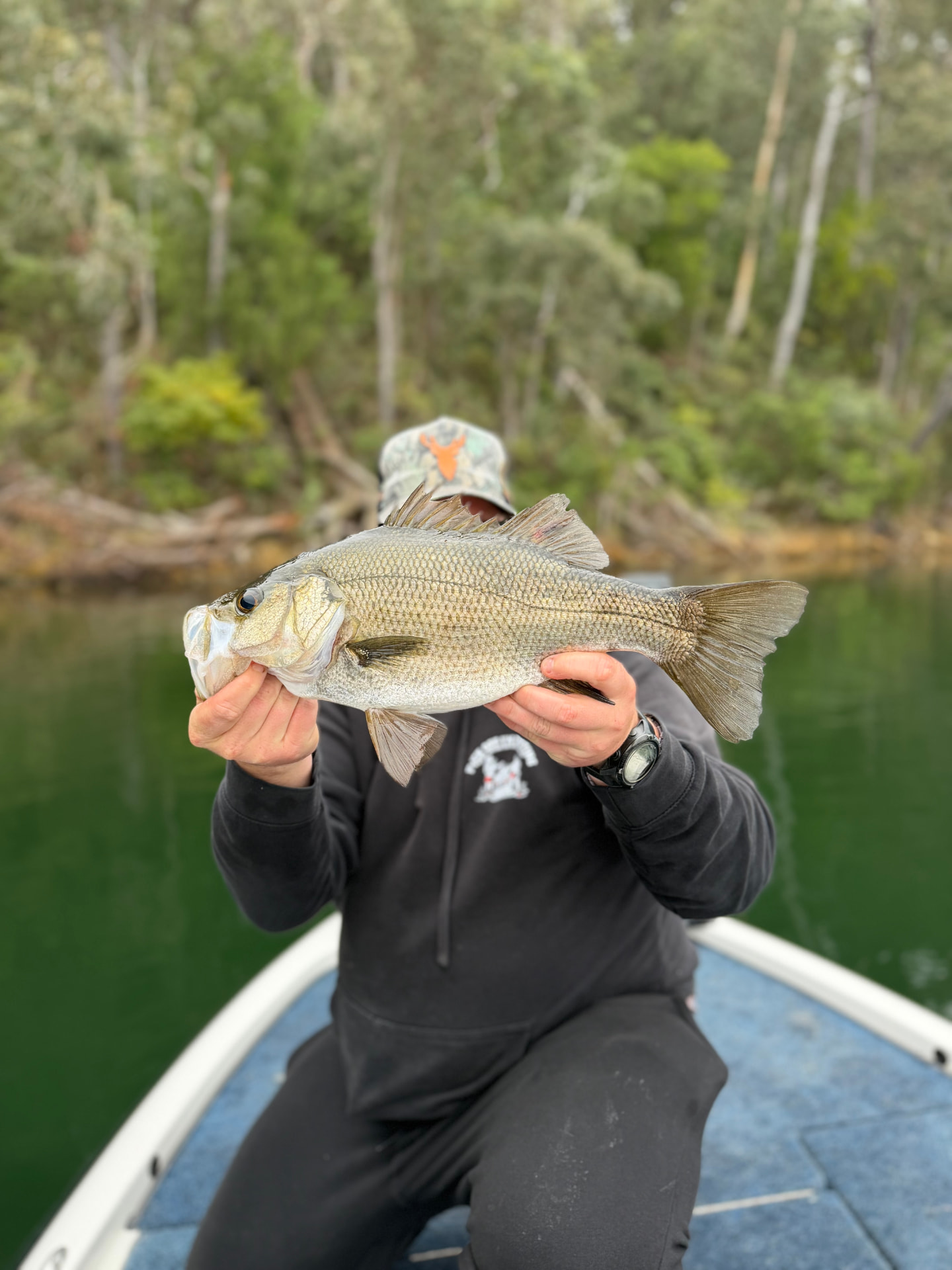 A guest holding a dusky flathead on the boat in the Mallacoota lake system