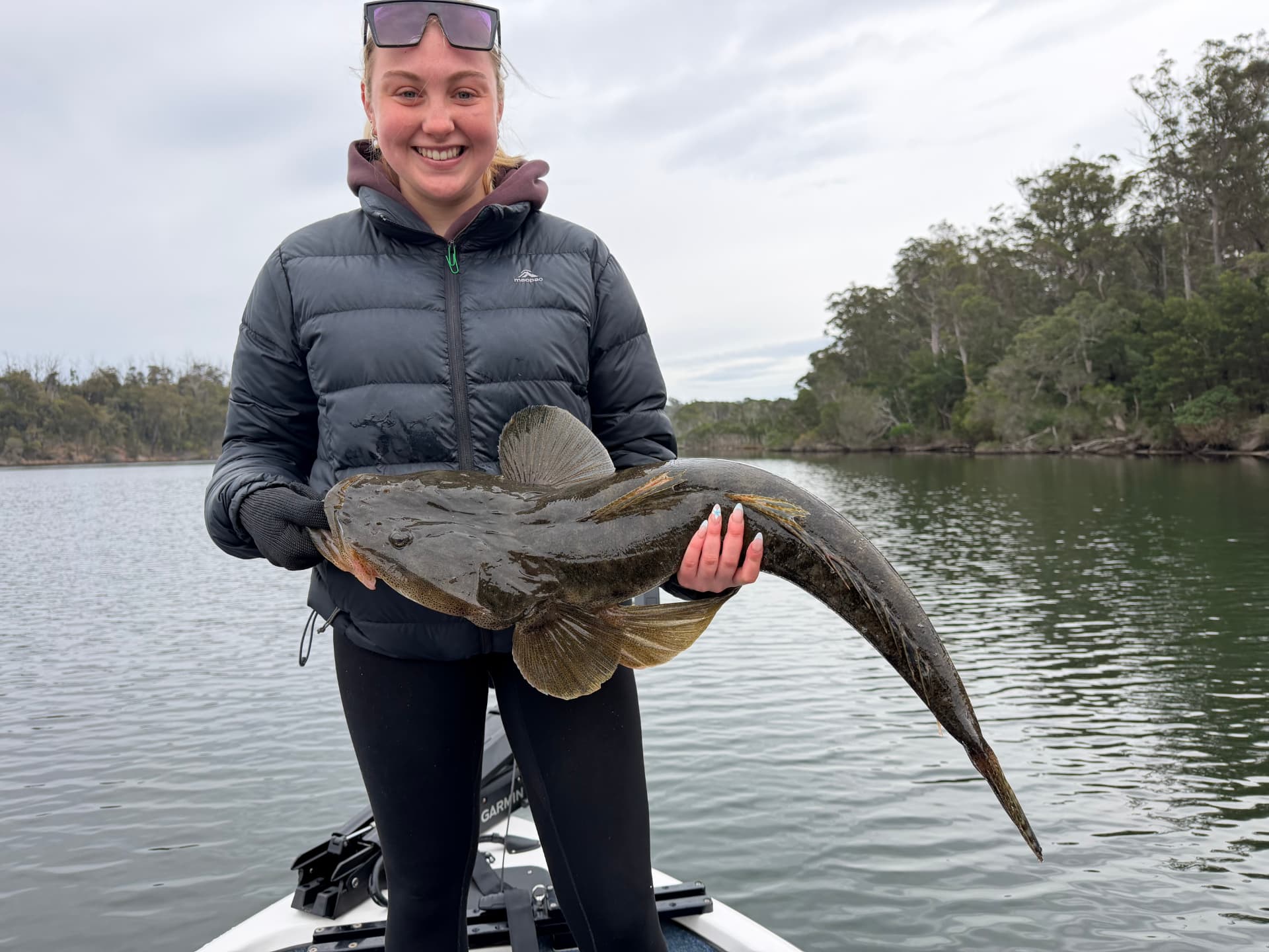 A smiling guest holding a very large dusky flathead on the Mallacoota lake system